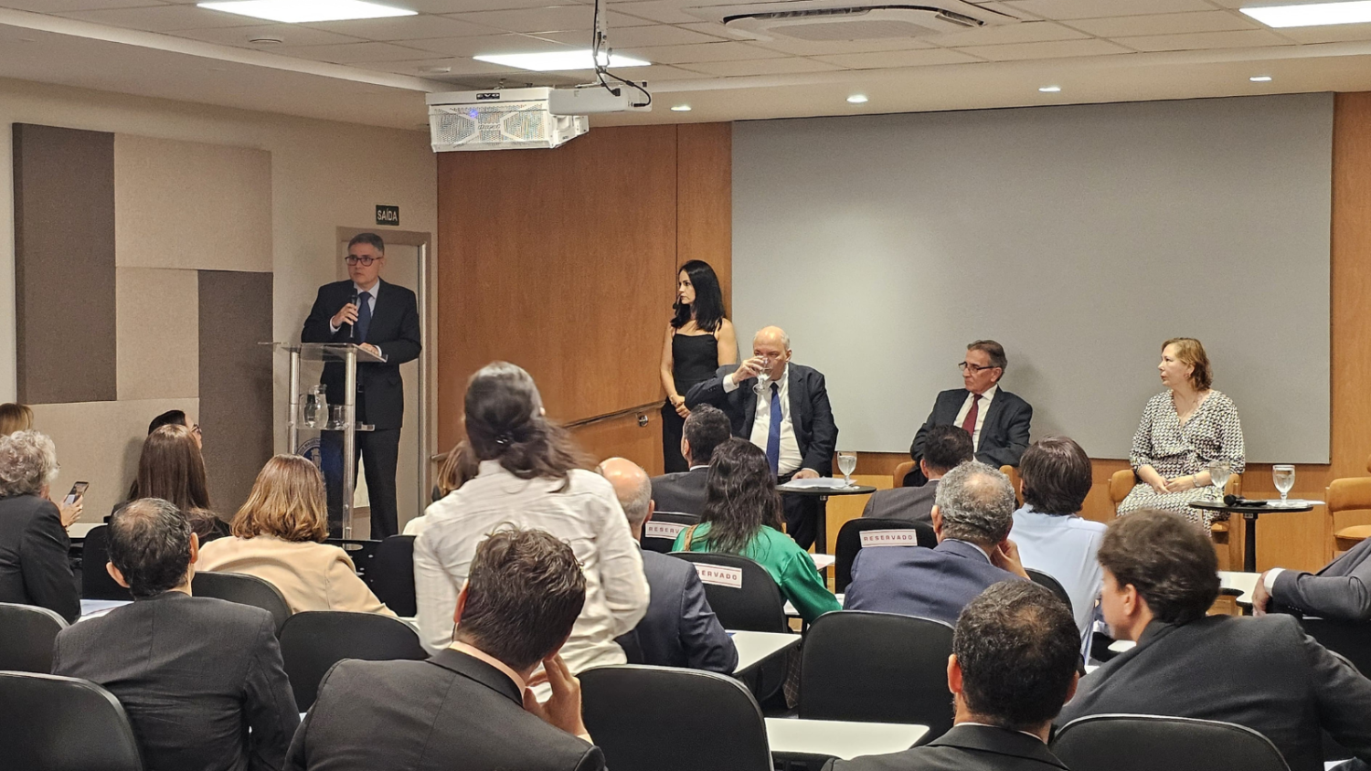 Fernando Mattos fala de pé, no púlpito, de frente para o auditório  repleto de magistrados e magistradas