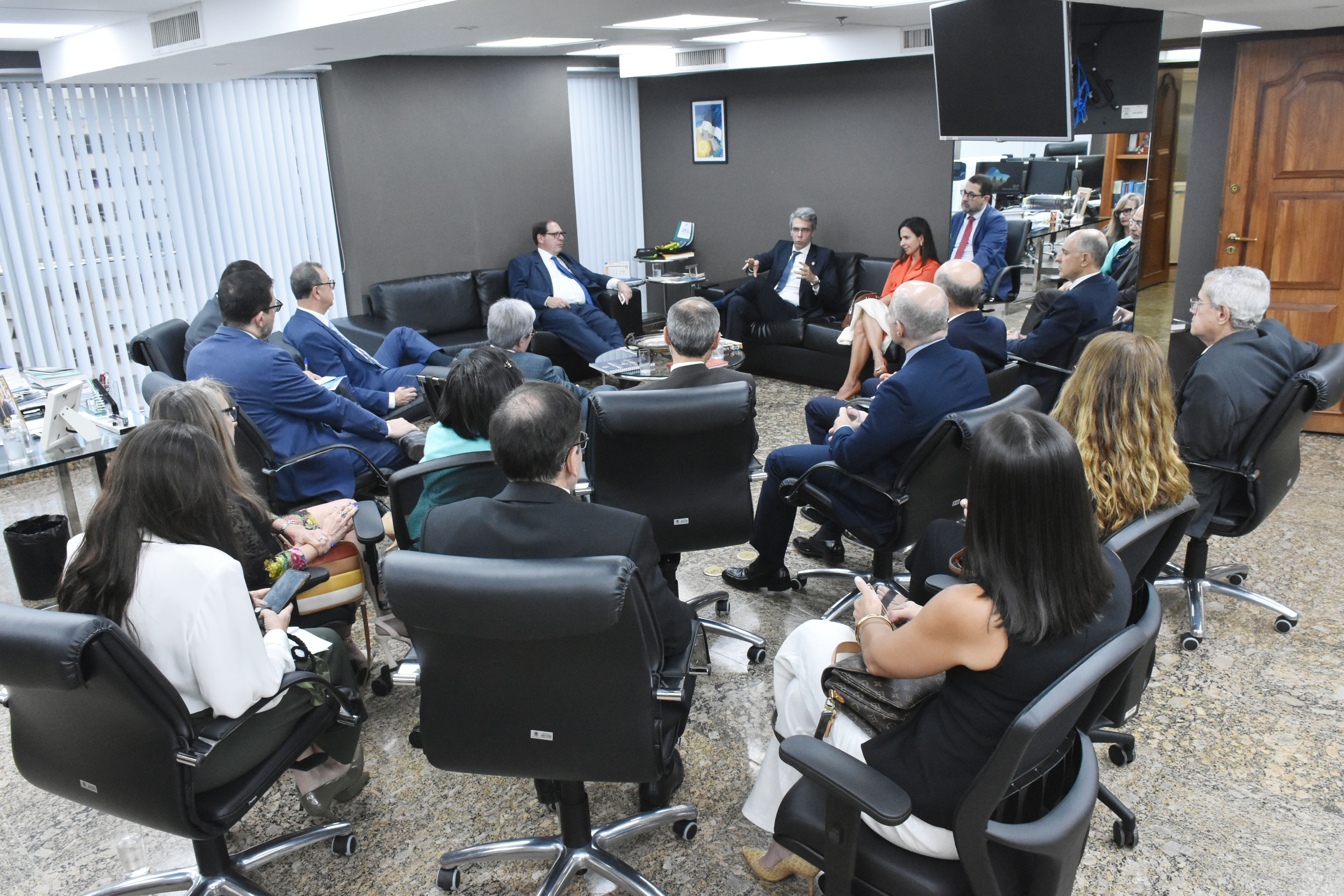 Sala da presidência do TRF2, com vários homens de terno e mulheres em reunião
