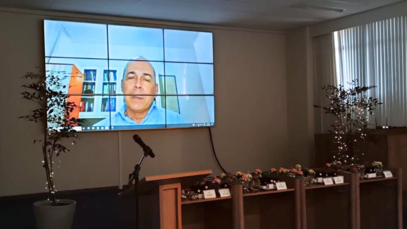 No telão, aparece um homem de camisa azul falando