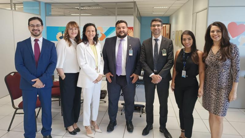 três homens e quatro mulheres de pé sorrindo para a câmera