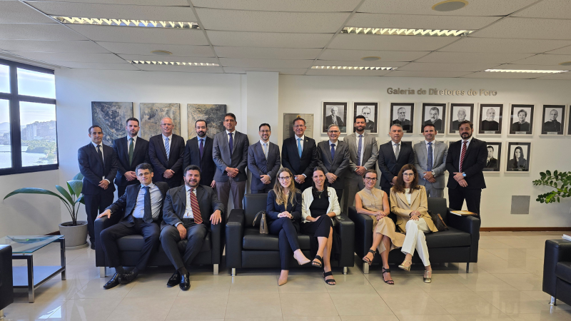 16 homens e mulheres posam para a foto, parte em pé e outra sentada