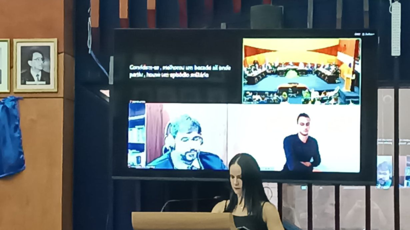 Imagem de juiz no telão acompanhando a solenidade por videoconferência