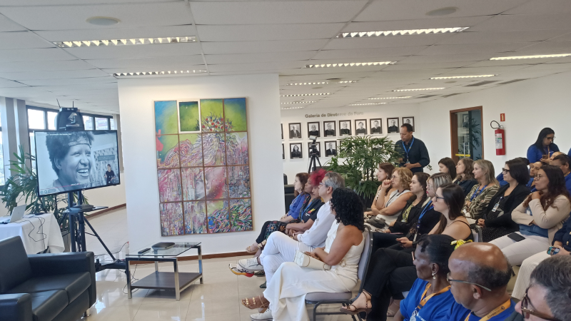 Público acompanha a exibição de um documentário em telão durante evento realizado na Justiça Federal.