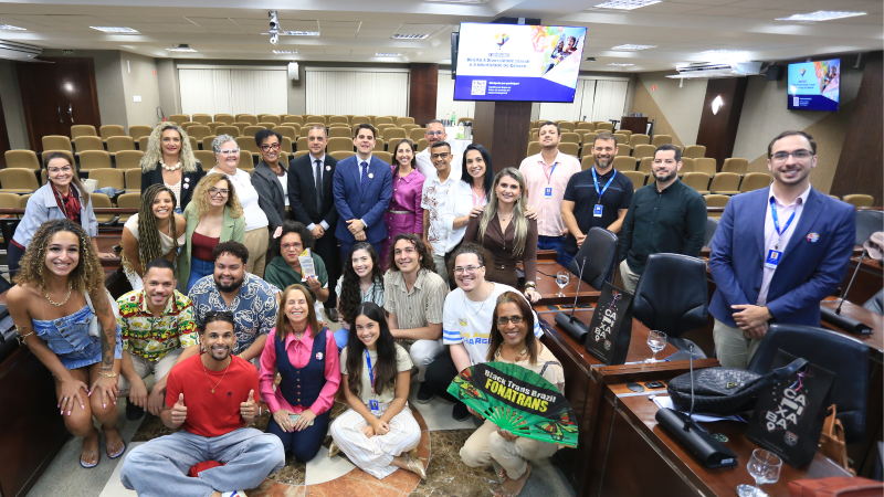 Grupo de cerca de 30 participantes do evento posam sorrindo para a foto