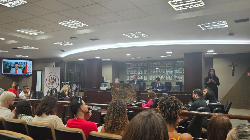 auditório com mesa de palestrantes à frente