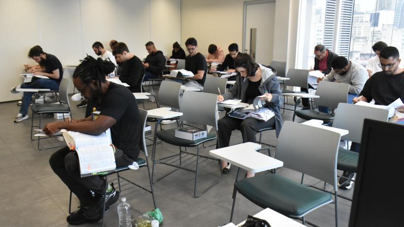 Sala com candidatos e candidatas fazendo a prova