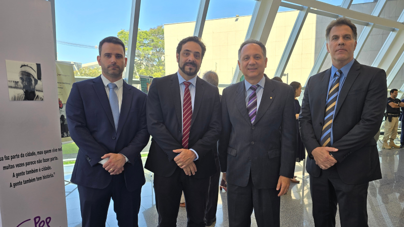 Quatro homens de terno escuro posam para a foto