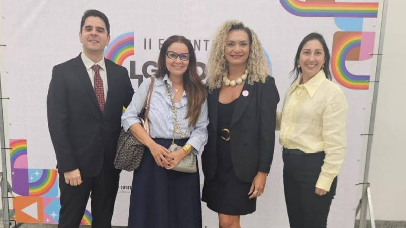 Um homem e três mulheres posam sorrindo para a foto