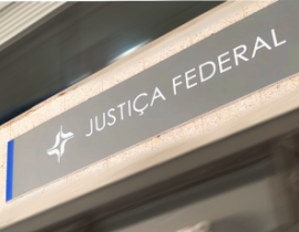 Fachada com marca da Justiça Federal em branco sobre fundo cinza