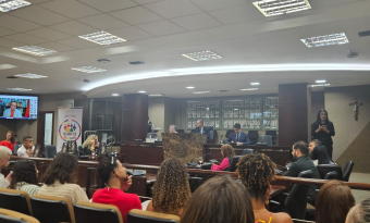 auditório com mesa de palestrantes à frente
