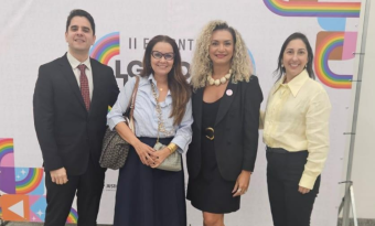 Um homem e três mulheres posam sorrindo para a foto