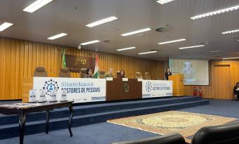 mesa do evento com banner branco e letras azuis