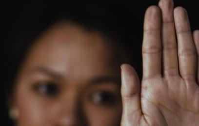 Mulher fazendo sinal de "pare" com a mão