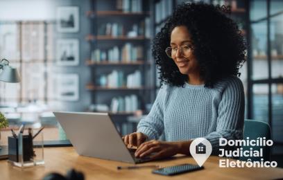 Mulher utilizando um laptop para realizar cadastro no Domicílio Judicial Eletrônico