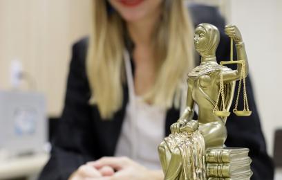 Imagem de uma juíza ao lado da deusa da Justiça