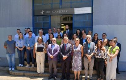 Grupo de autoridades e servidores, de pé, em frente ao prédio do Arquivo da SJRJ