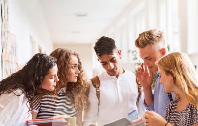 jovens de várias etnias em pé com papéis nas mãos