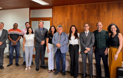 Sete homens e quatro mulheres de pé, sorrindo para a câmera