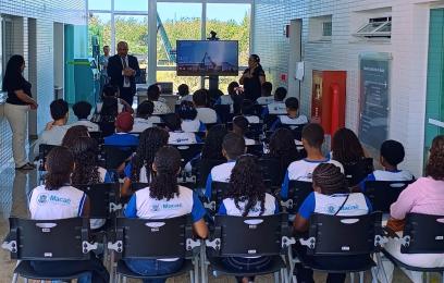 estudantes sentados de costas assistem à palestra