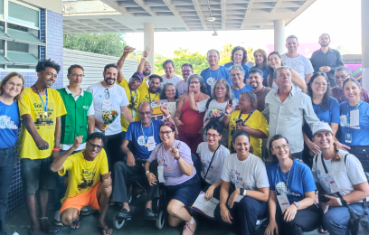 Grupo grande de pessoas posando para a foto, sorrindo, algumas delas com os braços levantados, vibrando por mais um mutirão realizado com sucesso