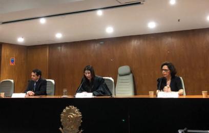 mulheres e homem brancos em mesa sentados lado a lado